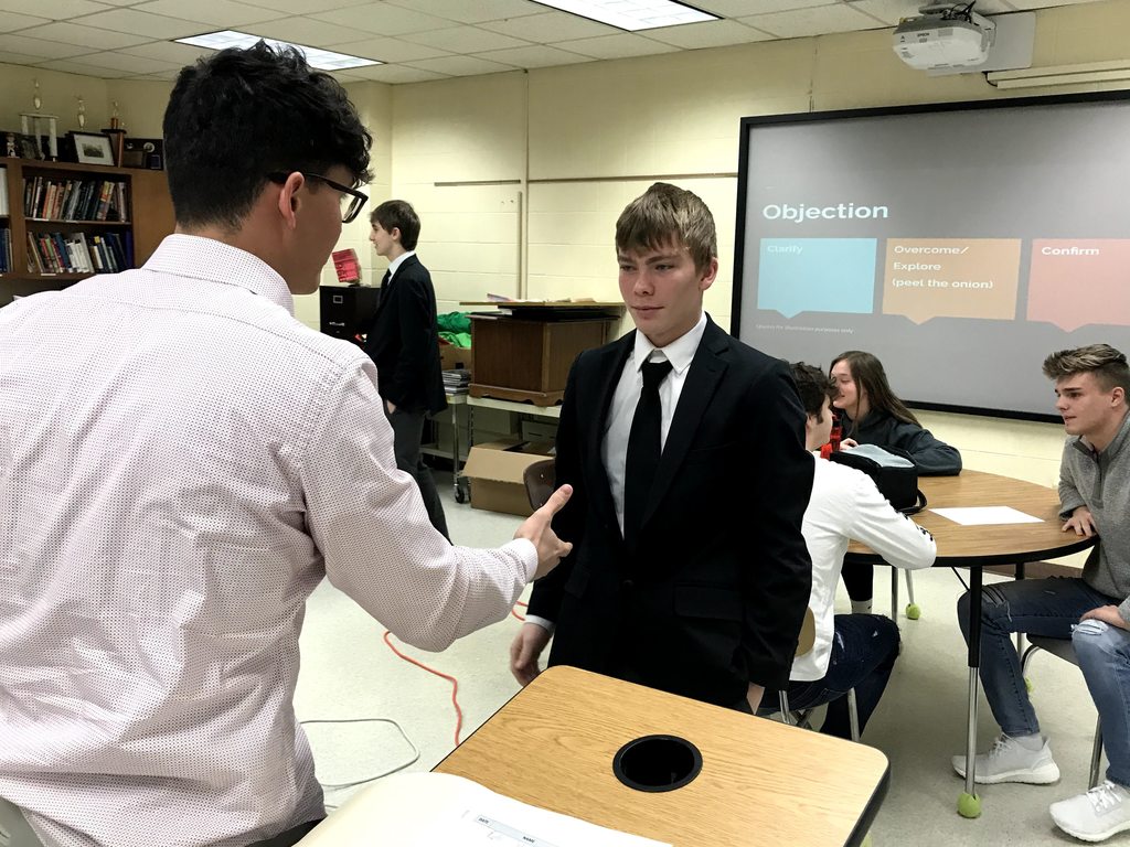 Noah working with a student during the mini-sales competition